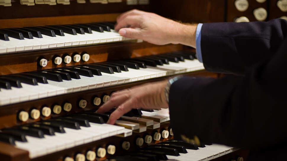 Hands playing on an organ
